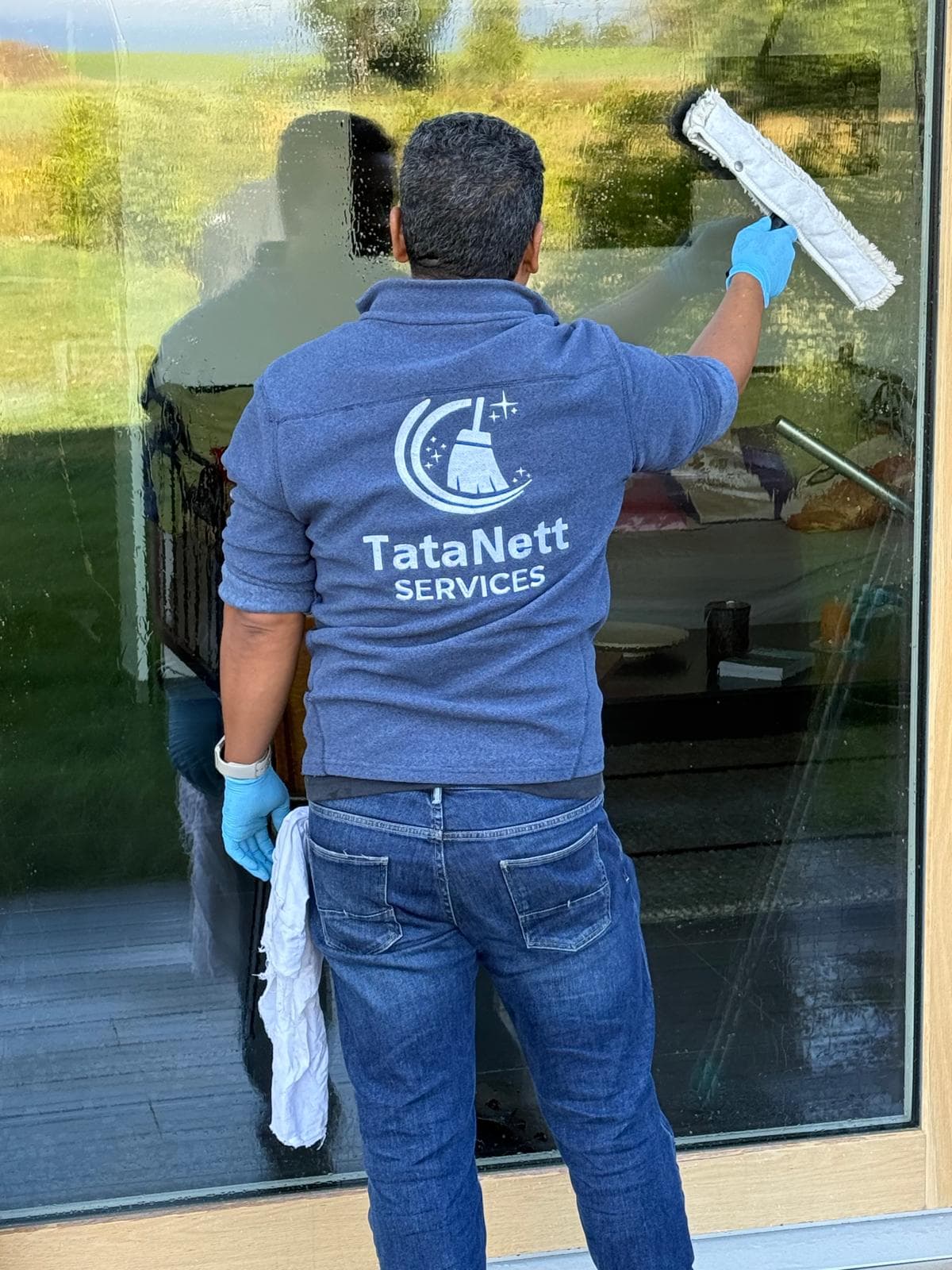 Tarcisio « Tata » de Souza, fondateur de TataNett Services, nettoyant une baie vitrée